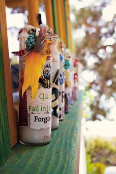 several bottles are lined up on a shelf with the words fall in love forever written on them