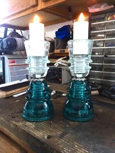 two teal glass candlesticks sitting on top of a wooden table