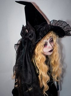 a woman with long blonde hair wearing a witches hat