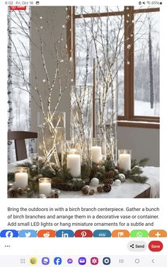 a table with candles and christmas decorations on it, in front of a large window