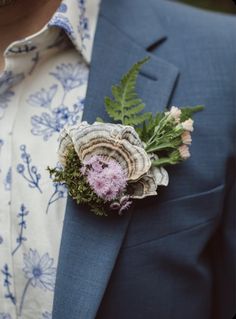 a man wearing a blue suit and flower boutonniere on his lapel