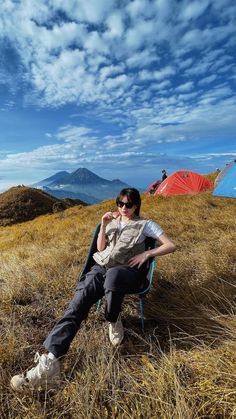 a woman sitting in a chair on top of a hill