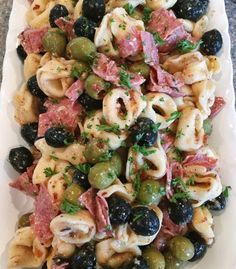 pasta salad with olives, ham and parsley on a platter ready to be eaten