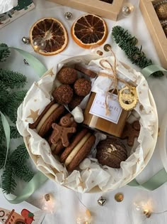 a basket filled with cookies, oranges and other holiday treats on top of a table