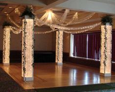 an empty dance floor is decorated with lights and greenery