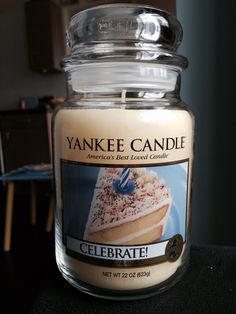 a yankee candle is sitting on a table in a room with other furniture and decor