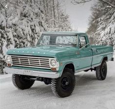 a green truck is parked in the snow