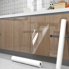 a roll of clear plastic sitting on the floor next to a kitchen counter with wooden cabinets