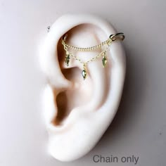 a pair of ear piercings with chains attached to them