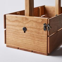 a close up of a wooden box on a white surface with two handles and one door open