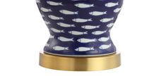 a blue and white vase with gold trimmings on it's base, featuring fish