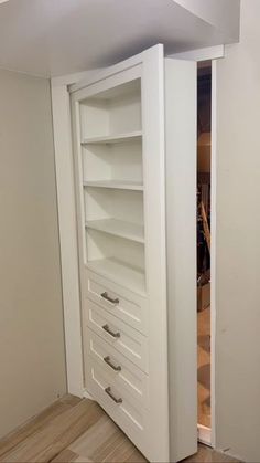 an empty white closet with drawers in it