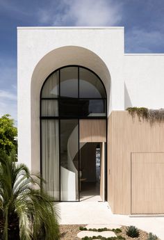 the entrance to a modern home with an arched window