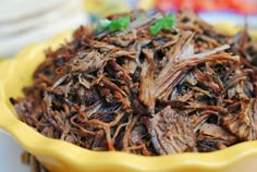 a yellow bowl filled with grasshoppers sitting on top of a table next to other plates