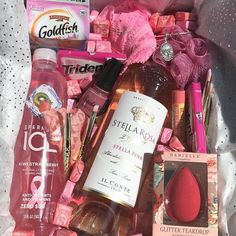 a bag filled with lots of different types of cosmetics and hygiene products on top of a white sheet