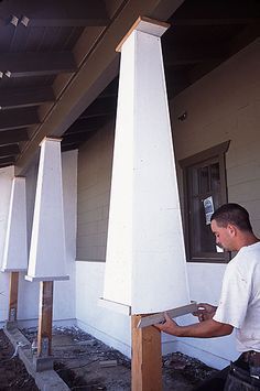 a man standing on the side of a building holding a piece of paper in his hand