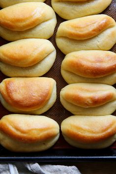 freshly baked bread rolls lined up on a baking sheet