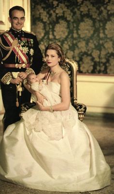 a man and woman in formal dress sitting next to each other on a chair together