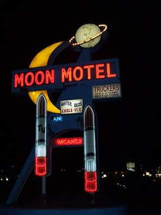 the moon motel sign is lit up at night with lights on it's sides