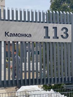 a man standing in front of a gate with the name kameka on it