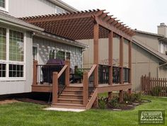 an outside view of a house with a deck and pergolated roof over it