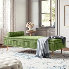 a living room with a green couch and white rugs on the floor next to a window