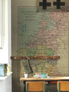 two desks in front of a wall with a map on it