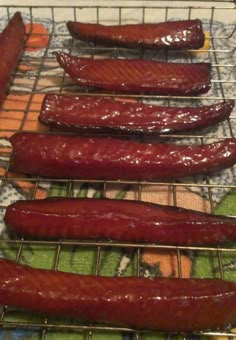 four sausages are being cooked on the grill