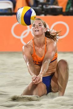 a woman in an orange shirt is playing volleyball