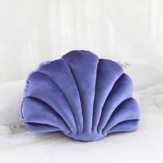 a blue pillow sitting on top of a white bed