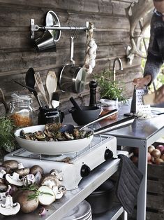 an outdoor kitchen with lots of clutter and cooking utensils on the counter