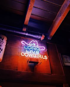 a neon sign that says long live cowgirls on the side of a building