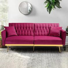 a living room with a pink couch and mirror