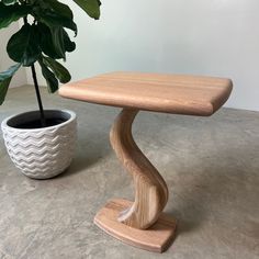 a wooden table next to a potted plant