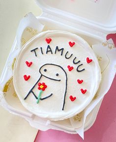 there is a cake in the box that says tamuuu with hearts on it