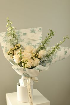 a bouquet of white roses and baby's breath in a vase