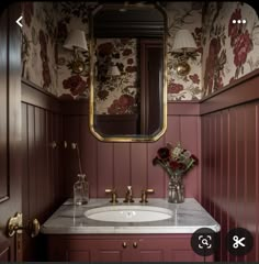 a bathroom sink with a mirror above it and flowers in the vase on the counter