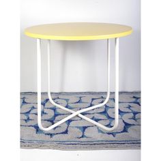 a yellow and white table sitting on top of a rug