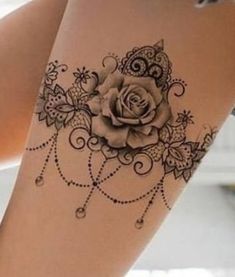 a woman's thigh with a rose tattoo on the side and an intricate design