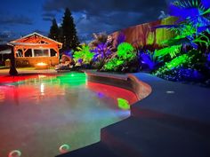 an outdoor pool lit up with colorful lights