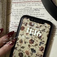 a woman's hand holding an iphone with the number 11 on it next to a book