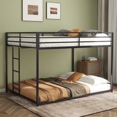 a black metal bunk bed sitting on top of a wooden floor next to a window