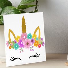 a unicorn face with flowers on it and a gold horn art boarder in the background