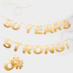 two gold foil letters that say 50 years strong