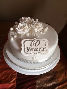 a white cake decorated with flowers and the words 60 years