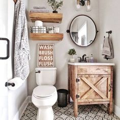 a white toilet sitting in a bathroom next to a wooden cabinet and mirror on the wall