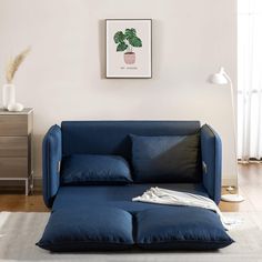 a living room with a blue couch and white rug