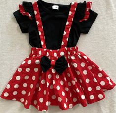 a red and white polka dot dress with black bow