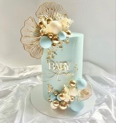 a blue and gold baby shower cake on a white table