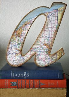 a wooden letter sitting on top of two books